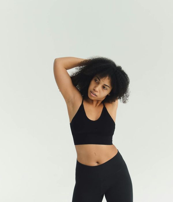 Woman in a calm yoga pose in a bright, minimalist studio.